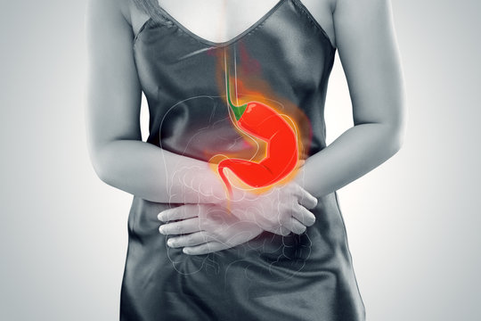 Woman Suffering From Acid Reflux Or Heartburn - Against gray background