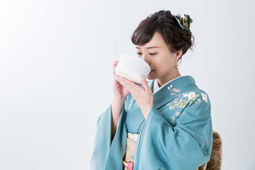 抹茶を飲む着物姿の女性
