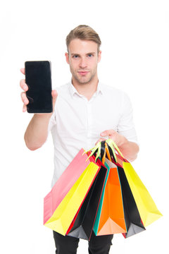 Guy buy fashionable clothes online with smartphone. Man happy client received packages purchases. Online shopping concept. Man takes advantages online shopping. Guy carries bunch colorful bags