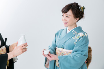 日本酒を注がれる着物姿の女性
