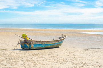Fototapeta na wymiar Fishing boat on the tropical beach with blue sky background at Huahin, Thailand