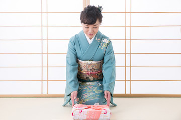 引き出物と着物姿の女性（笑顔）
