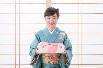 引き出物と着物姿の女性（笑顔）
