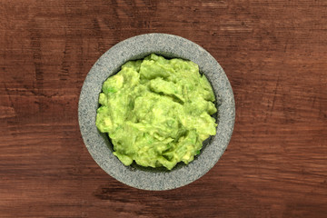 A photo of guacamole sauce in a molcajete, traditional Mexican mortar
