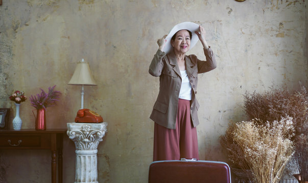 Asian senior woman vintage hat, retro fashion with travel luggage luxury retriement life