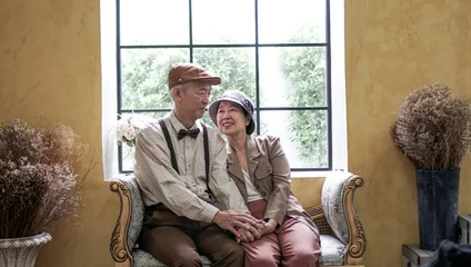 Fotobehang Asian senior couple smiling dress vintage retro style in luxury house with tuscan style yellow wall © glowonconcept