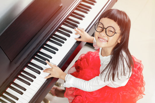 Little asian girl very happy to play piano