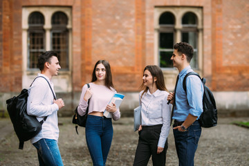 Obraz premium Group of happy students - two women and two men. Four people on the university campus