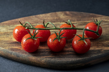 Tomatoes on the vine on wooden board
