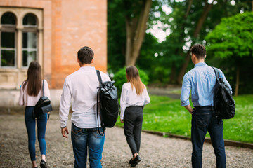 Obraz premium Rear view of students walking together in campus outdoors