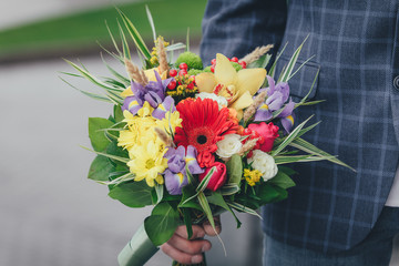 a bouquet of spring  flowers in a man's hand