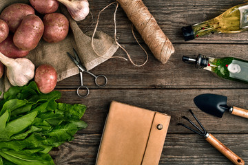 Fresh potatoes, oil, garlic and spicy herbs on a kitchen wooden background. Fresh vegetables from...