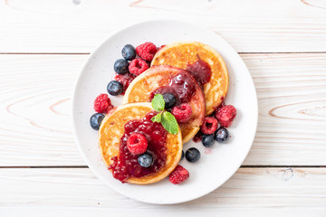 pancake with fresh raspberries and blueberries - obrazy, fototapety, plakaty