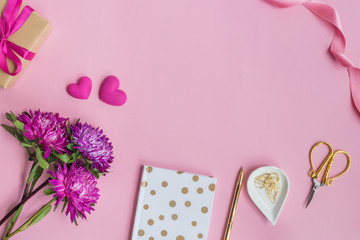 Flat lay desk with pink flowers, notebook and red hearts