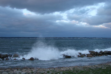 Panorama of the troubled North Sea near the coast of Denmark against the background of rainy clouds.