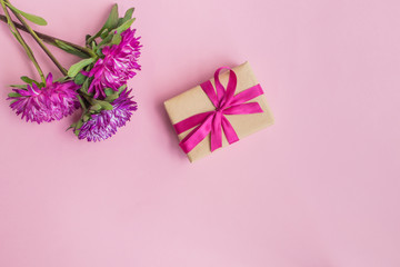 Pink flowers and gift box on a pink background