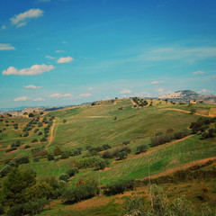 Sunny day in Italy. Fields and hills of Rural Sicily. Aged photo. Typical Sicily landscape. Walkways through the meadows.