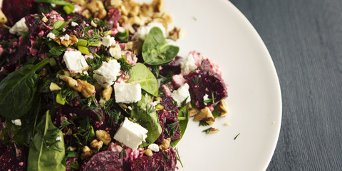 Beetroot salad with cottage cheese, baby spinach and walnuts. European cuisine. Organic food. Vegetarian appetizer. Healthy lifestyle. Simple side dish. Wide photo.