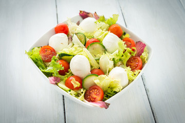 Insalata fresca con mozzarelline, cetrioli, lattuga, radicchio e pomodori