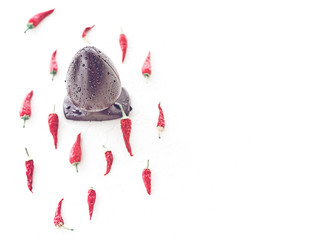 The rubber anal plug is covered with water drops and is on a white background. Nearby there are red...