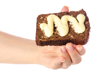 Piece of bread with sauce mayonnaise in hand on white background isolation