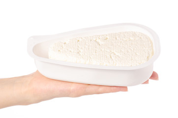 Cottage cheese in a plastic container in hand on a white background isolation