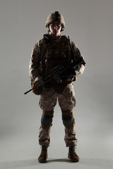 Soldier in camouflage holding rifle