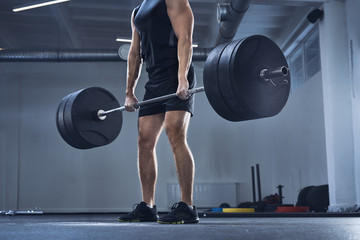 Athletic man doing deadlift exercise at gym