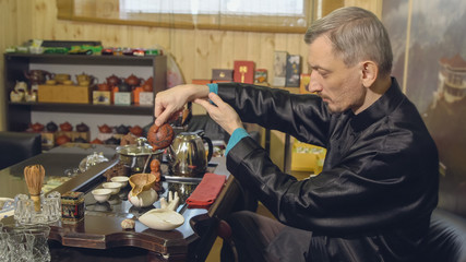 Master pours tea leaves with water. Tea ceremony