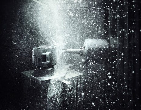 CNC machine drilling into cylinder head with coolant