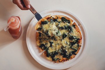 Slice of hot spinach pizza on table