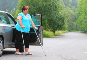 Disabled woman upgoing from a car. Transportation and travel for handicapped people.