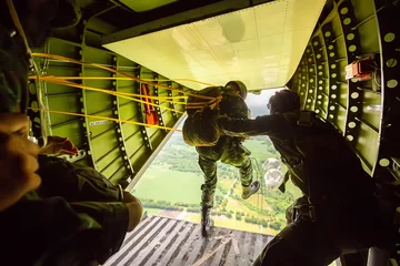 Gardinen Rangers mit dem Fallschirm aus Militärflugzeugen, Soldaten mit Fallschirmen aus dem Flugzeug, isolierter Luftsoldat, Fallschirmspringen, Fallschirmjäger, die aus einem Flugzeug springen. © funfunphoto