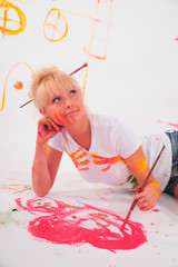 Beautiful young woman painter with paint brush in hands,
