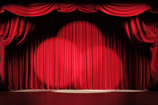 Theater stage with red velvet curtains with spotlights