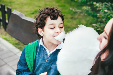 Happy Mother and son eating cotton candy in park