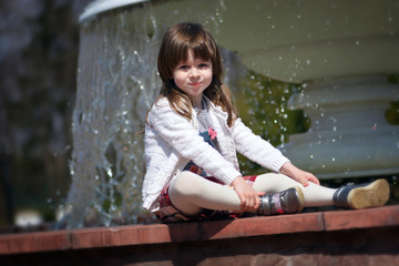 Adorable little girl's portrait by the fountain