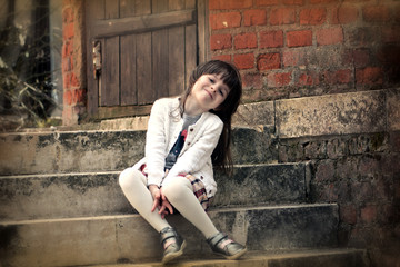 Adorable little girl's portrait sitting on stairs