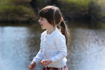 Adorable little girl's portrait by the lake