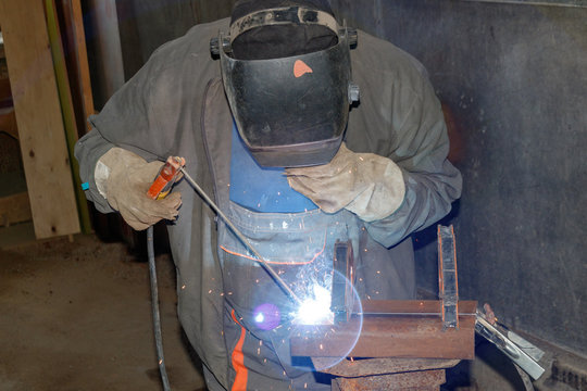 Electric welding. Worker welding metal plates.