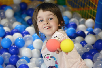 Little girl wih colorful soft balls