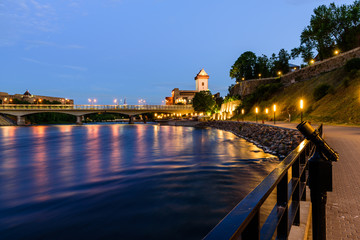 Beautiful night view of Narva Castle with tall Herman's tower and the ancient Russian fortress in Ivangorod, the monument and popular tourist attraction on the border with Estonia, Narva, Estonia