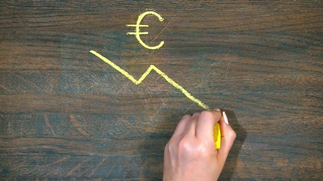 Closeup of hand draws on a wooden board. The fall of the euro and the growth of the dollar .