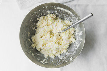 Cooking cabbage salad: cabbage with mayonnaise and salt in a metal bowl, top view