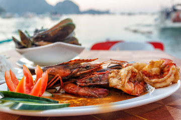A dish of fried prawns on the beach. Evening dinner by the sea with fried shrimps.