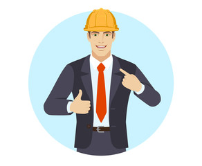 Self promotion. Businessman in construction helmet  pointing the finger at himself and showing thumb up