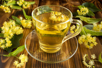 Tea with linden on the brown wooden background