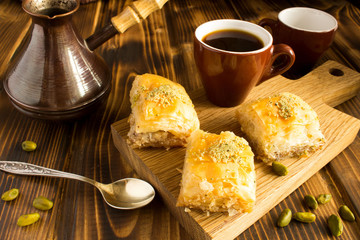 Turkish delight and  coffee on the cutting board on the  brown  wooden background