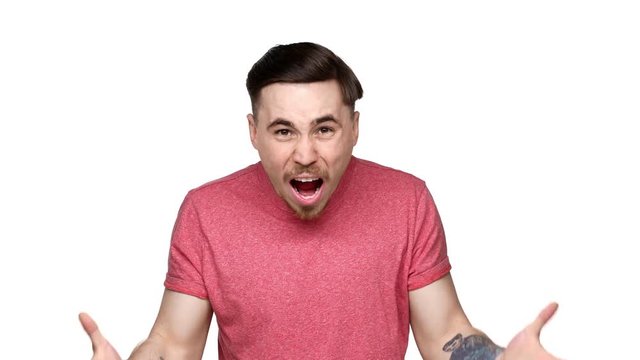 Portrait of irritated puzzled man 30s gesturing and screaming why question in resentment, isolated over white background. Concept of emotions