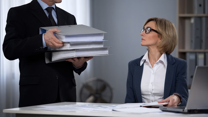 Strict boss overloading worker with work, prejudiced attitudes towards employees